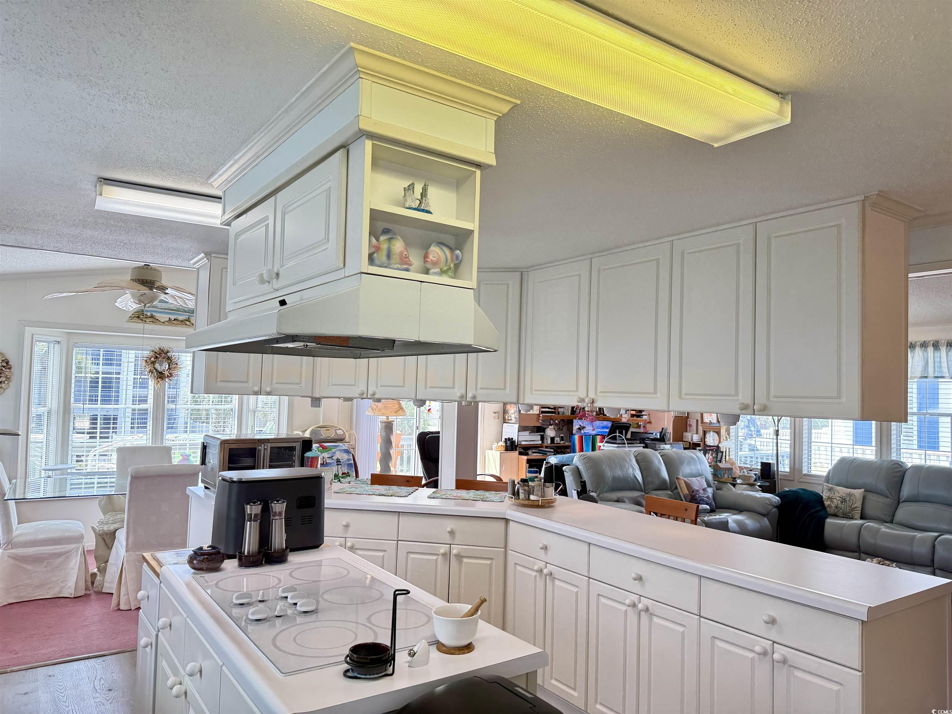 1506 Mason Circle Surfside Beach, SC 29575 - Photo 33 of 33 Kitchen with under cabinet range hood, a textured ceiling, white electric cooktop, open floor plan, and ceiling fan