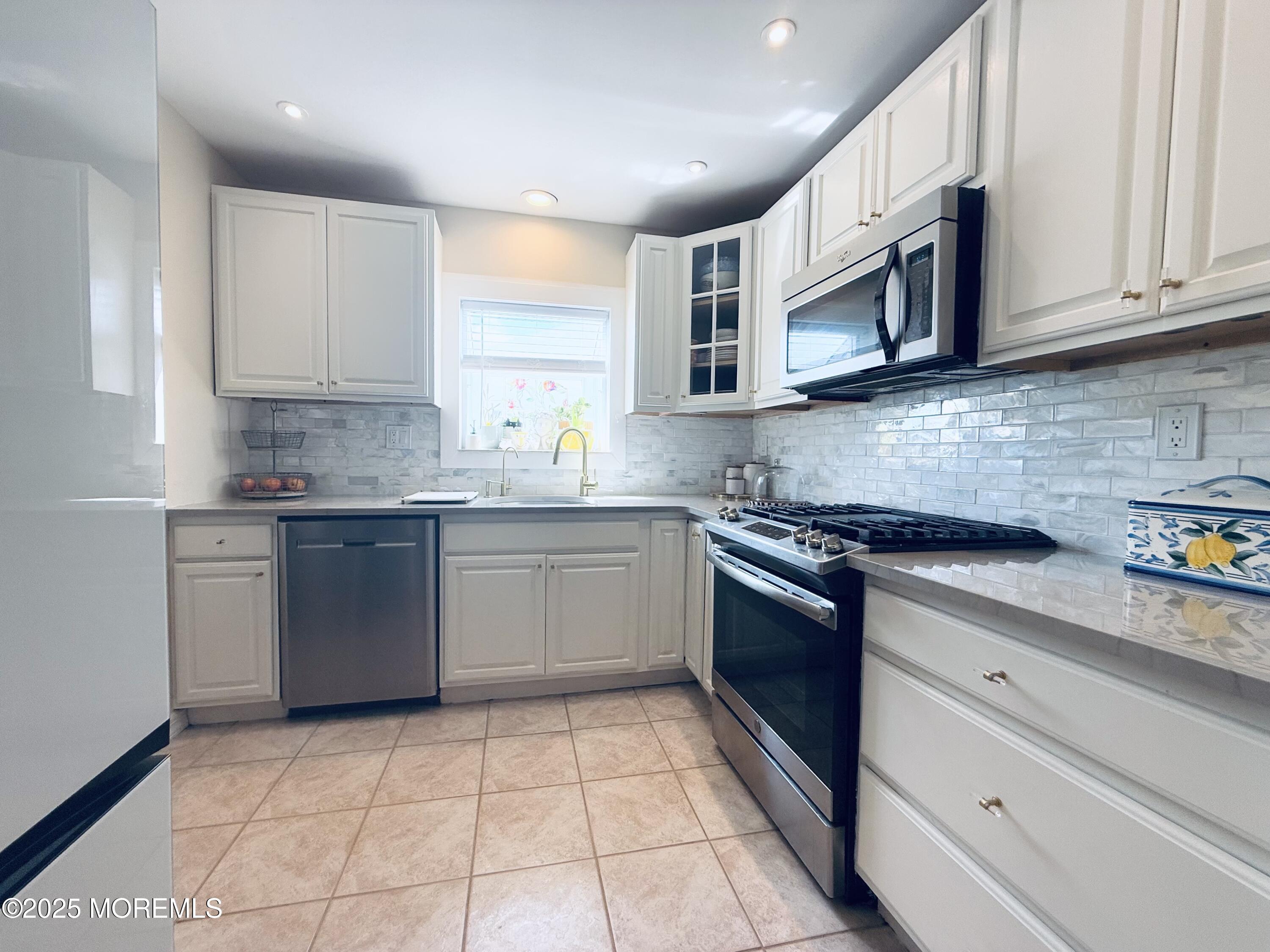 20 Long Road Freehold, NJ 07728 - Photo 5 of 20 a kitchen with stainless steel appliances granite countertop a sink a stove a microwave and cabinets