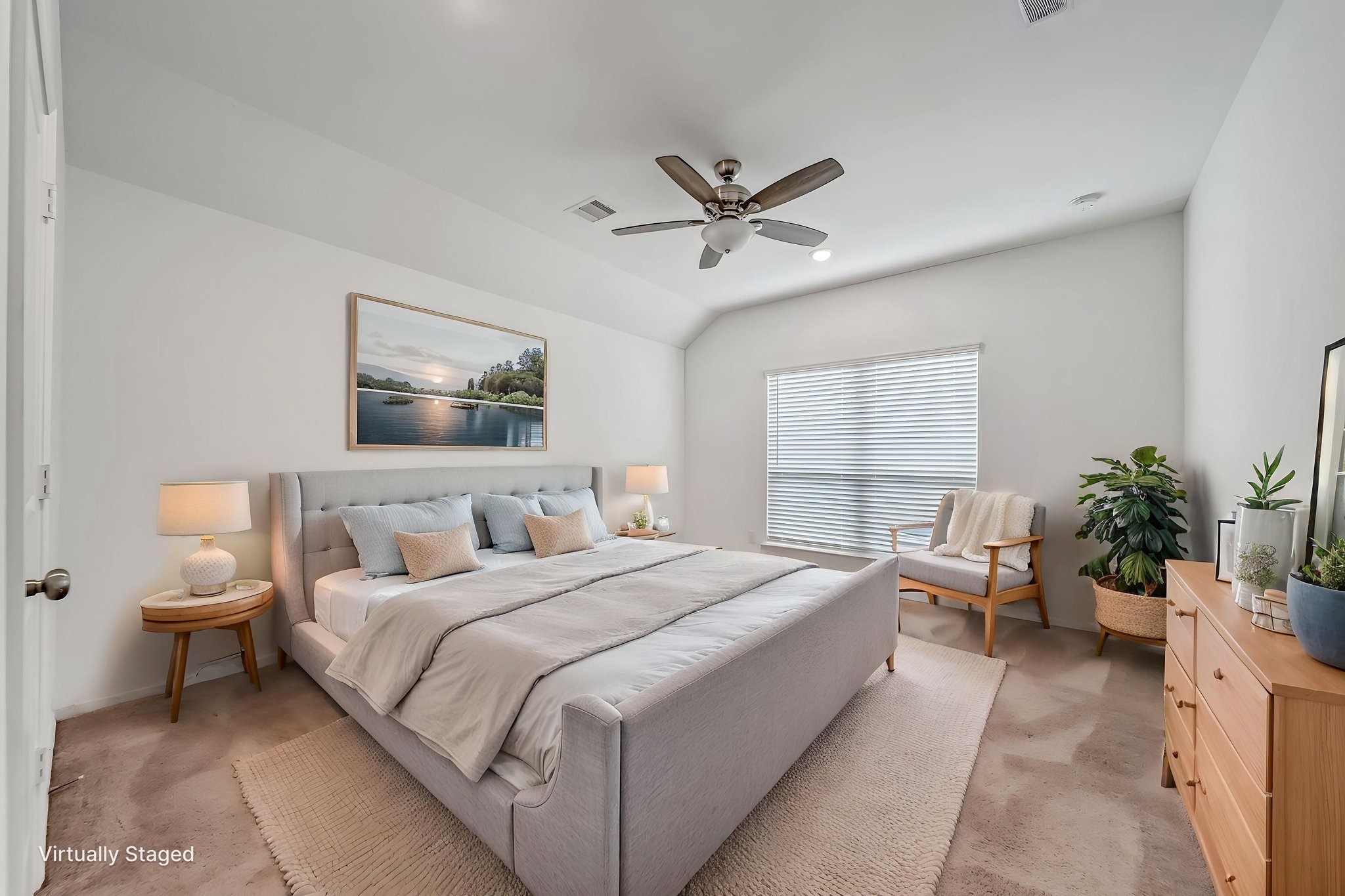 2847 Mistygate Court Conroe, TX 77301 - Photo 15 of 27 This is a bright, airy bedroom featuring a large window with blinds, a ceiling fan, and neutral decor. It includes a comfortable bed, bedside tables with lamps, a dresser, and a cozy chair with a plant, creating a serene and inviting atmosphere.