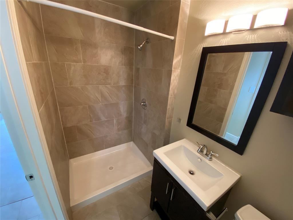2402 Rio Grande Street, Unit 4 Austin, TX 78705 - Photo 5 of 5 Bathroom featuring a walk-in shower with large format tile surround, a built-in shower niche, and a white shower pan