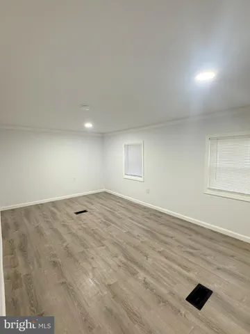 an empty room with window and wooden floor