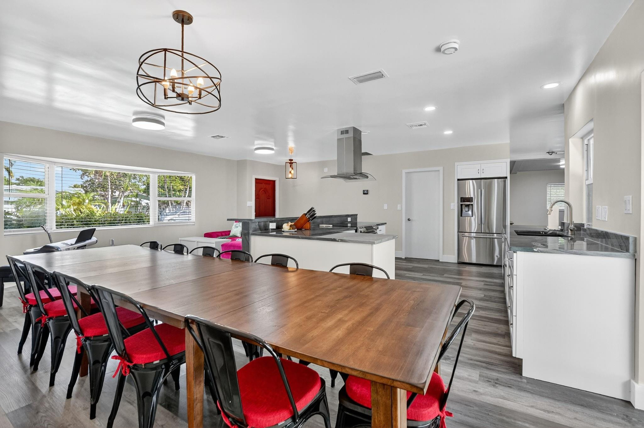 1650 Northwest 9th Street Boca Raton, FL 33486 - Photo 15 of 57 a kitchen with stainless steel appliances granite countertop a dining table chairs stove and kitchen view