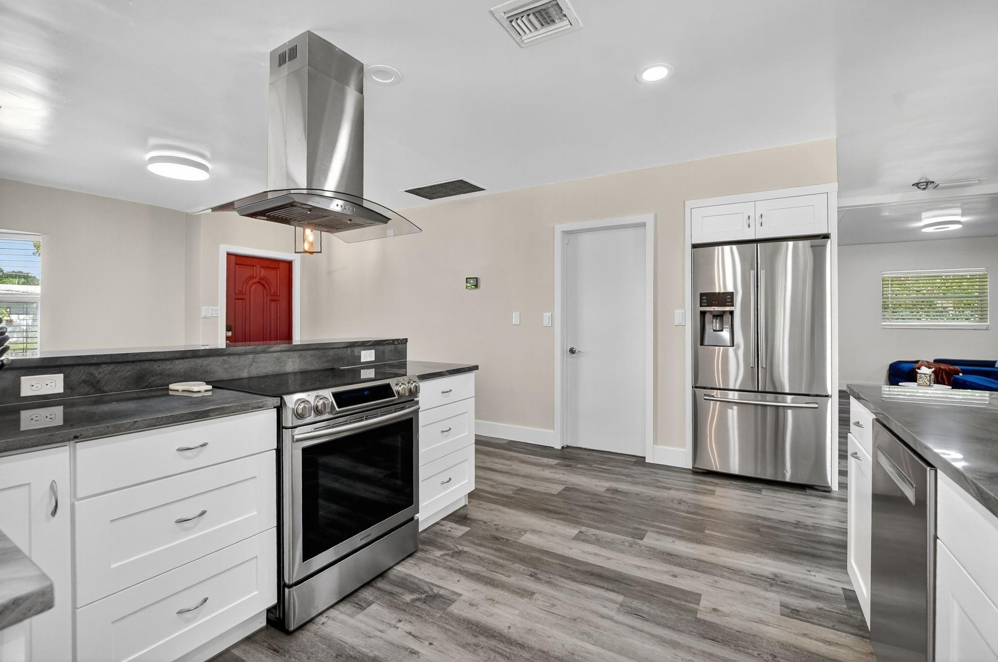 1650 Northwest 9th Street Boca Raton, FL 33486 - Photo 17 of 57 a kitchen with stainless steel appliances a stove a refrigerator and a refrigerator with wooden floors
