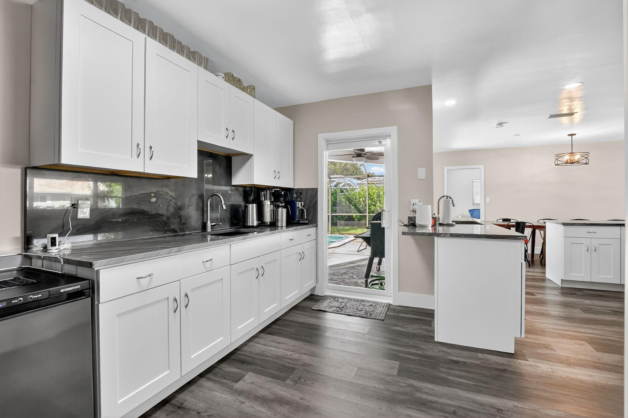 1650 Northwest 9th Street Boca Raton, FL 33486 - Photo 19 of 57 a kitchen with kitchen island granite countertop a stove top oven a sink a counter space and cabinets