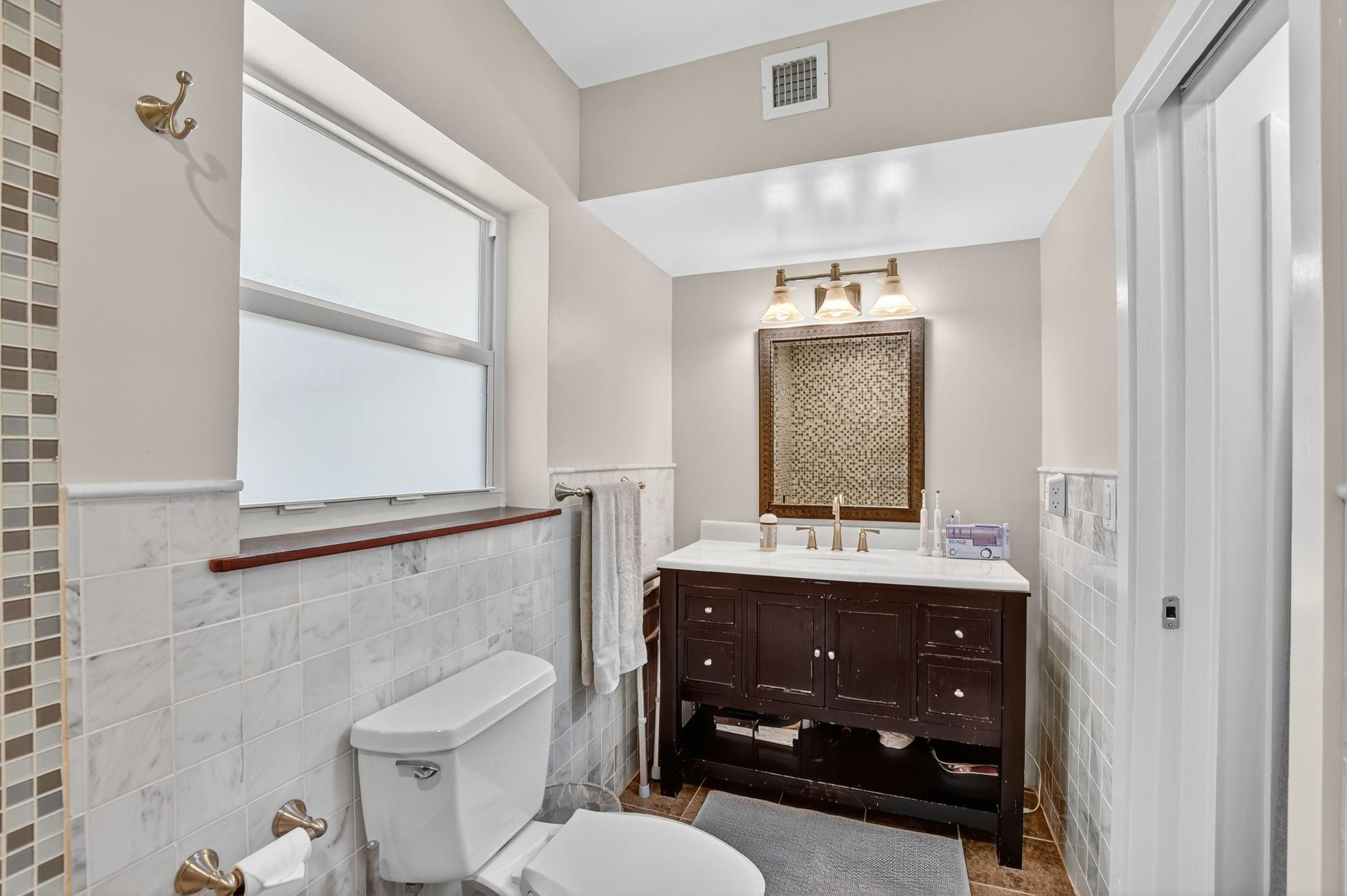 1650 Northwest 9th Street Boca Raton, FL 33486 - Photo 27 of 57 a bathroom with a granite countertop sink toilet a mirror and shower