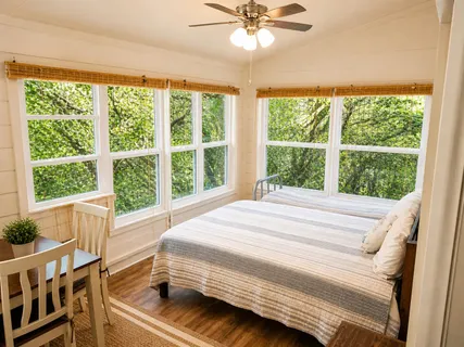 a bedroom with a bed and a large window
