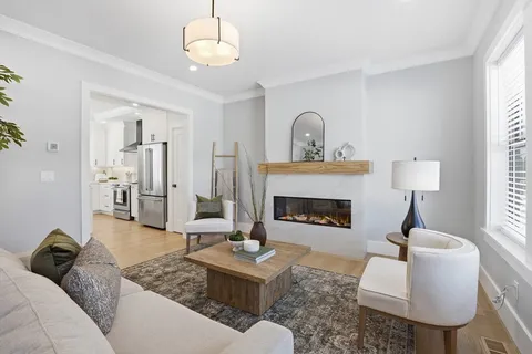 a living room with furniture a fireplace and a chandelier