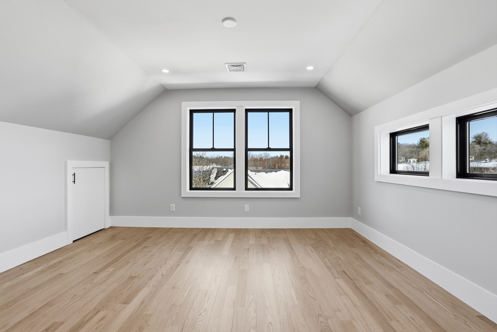 10 Webber Avenue, Unit 101 Bedford, MA 01730 - Photo 25 of 35 a view of an empty room with wooden floor and a window