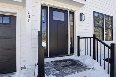 a view of a house with a yard covered in snow