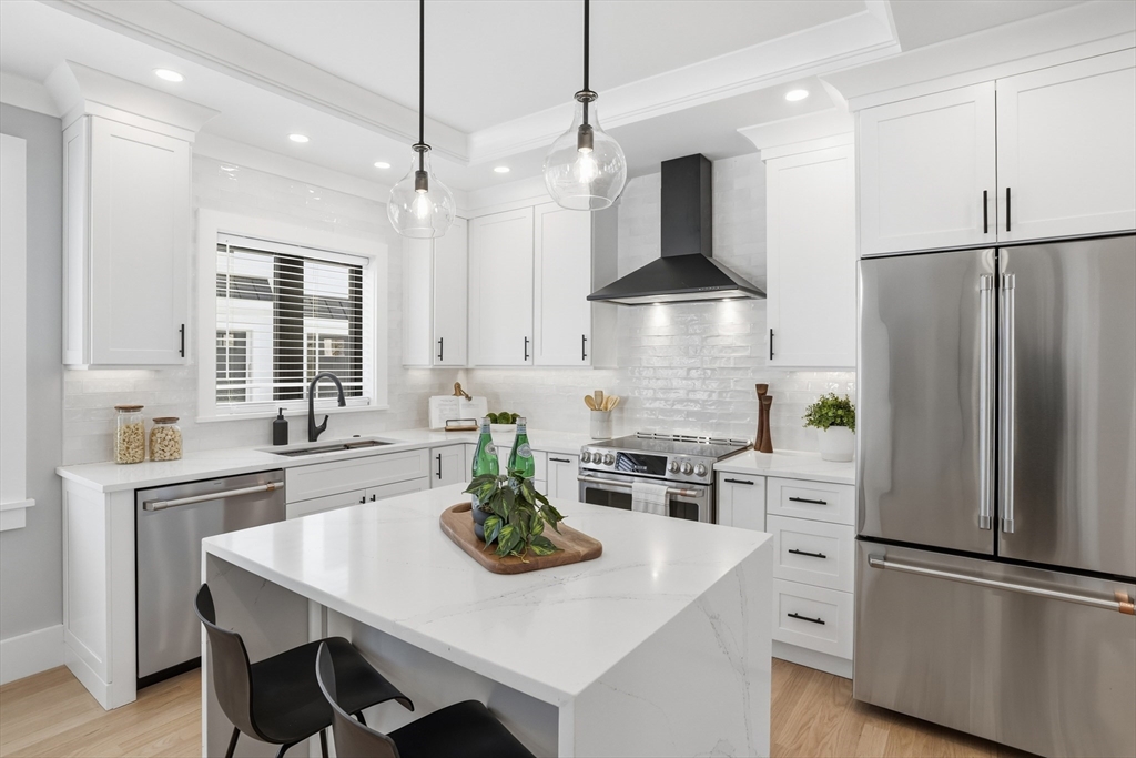 10 Webber Avenue, Unit 101 Bedford, MA 01730 - Photo 3 of 35 a kitchen with refrigerator cabinets and wooden floor