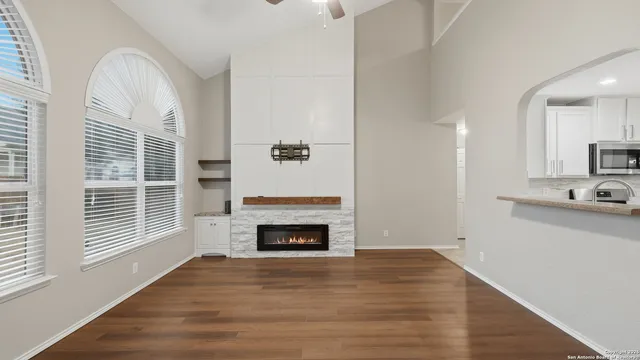 a view of empty room with a fireplace and wooden floor