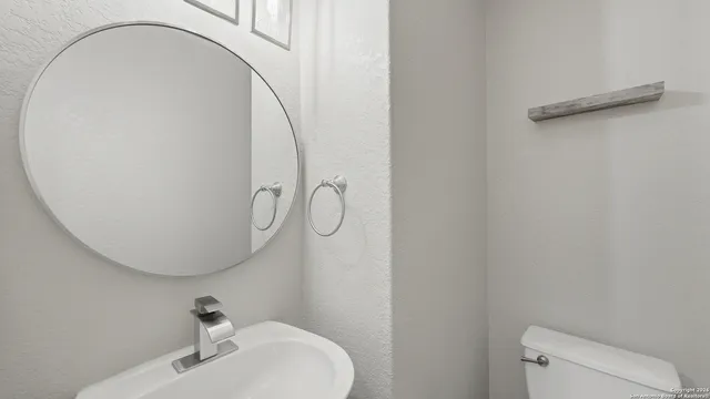 a bathroom with a sink a toilet and a mirror