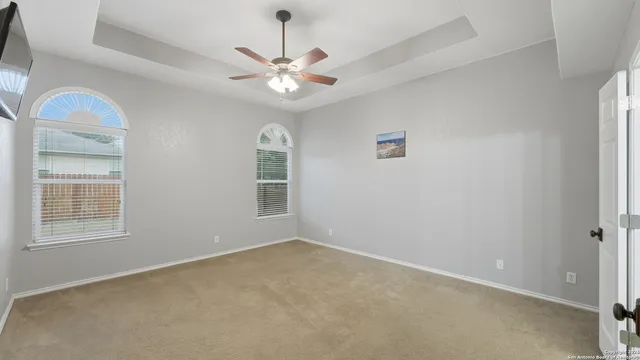 an empty room with windows and fan