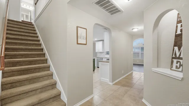 a view of an entryway with wooden floor and a kitchen