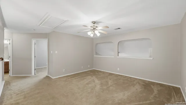 a view of an empty room with a ceiling fan