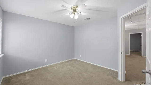 a view of a room with a ceiling fan and a fan