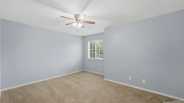 an empty room with a window and a fan