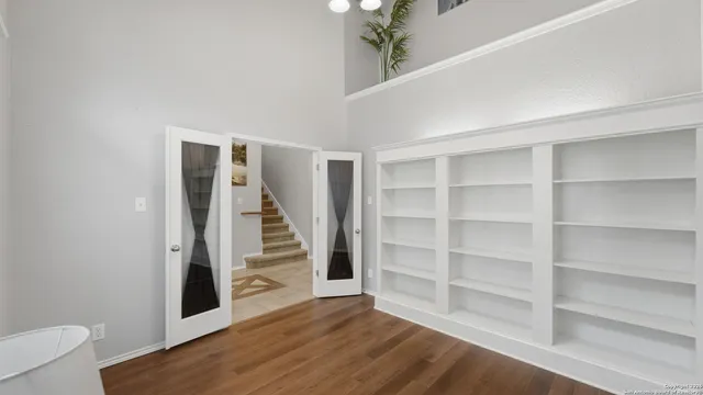 a view of an empty room with wooden floor and entryway