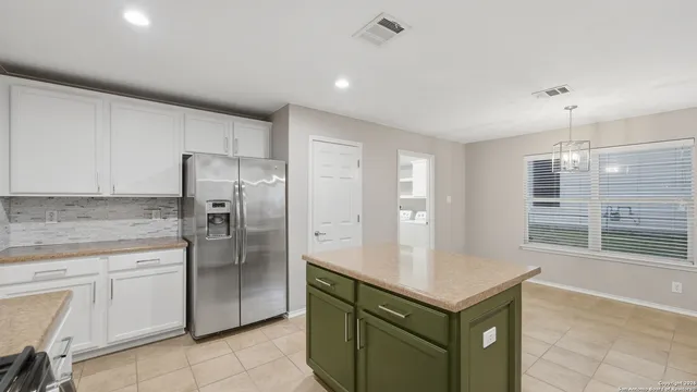 a kitchen with stainless steel appliances granite countertop a refrigerator a sink and a stove