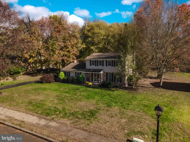 a view of a house with a big yard and large trees