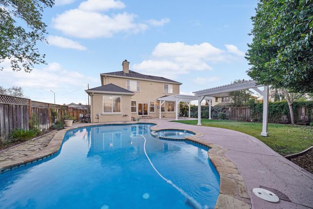 a view of a house with swimming pool and a yard