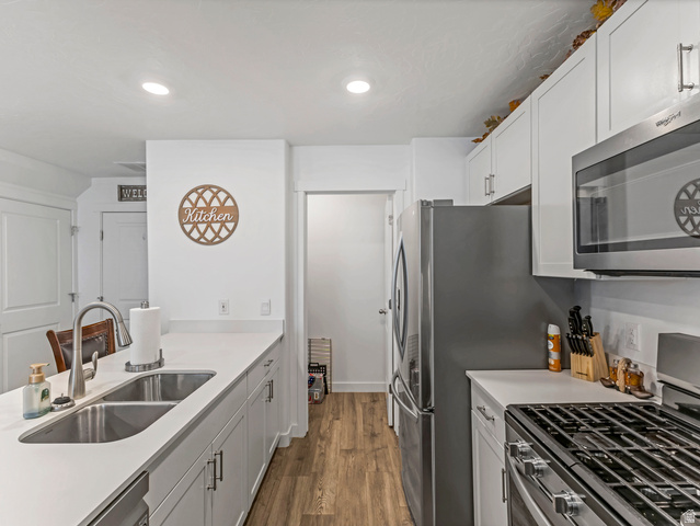 842 North Old Rnch Road Lehi, UT 84048 - Photo 7 of 17 Modern kitchen featuring white cabinetry, light countertops, wood-finish flooring, stainless steel appliances, and recessed lighting