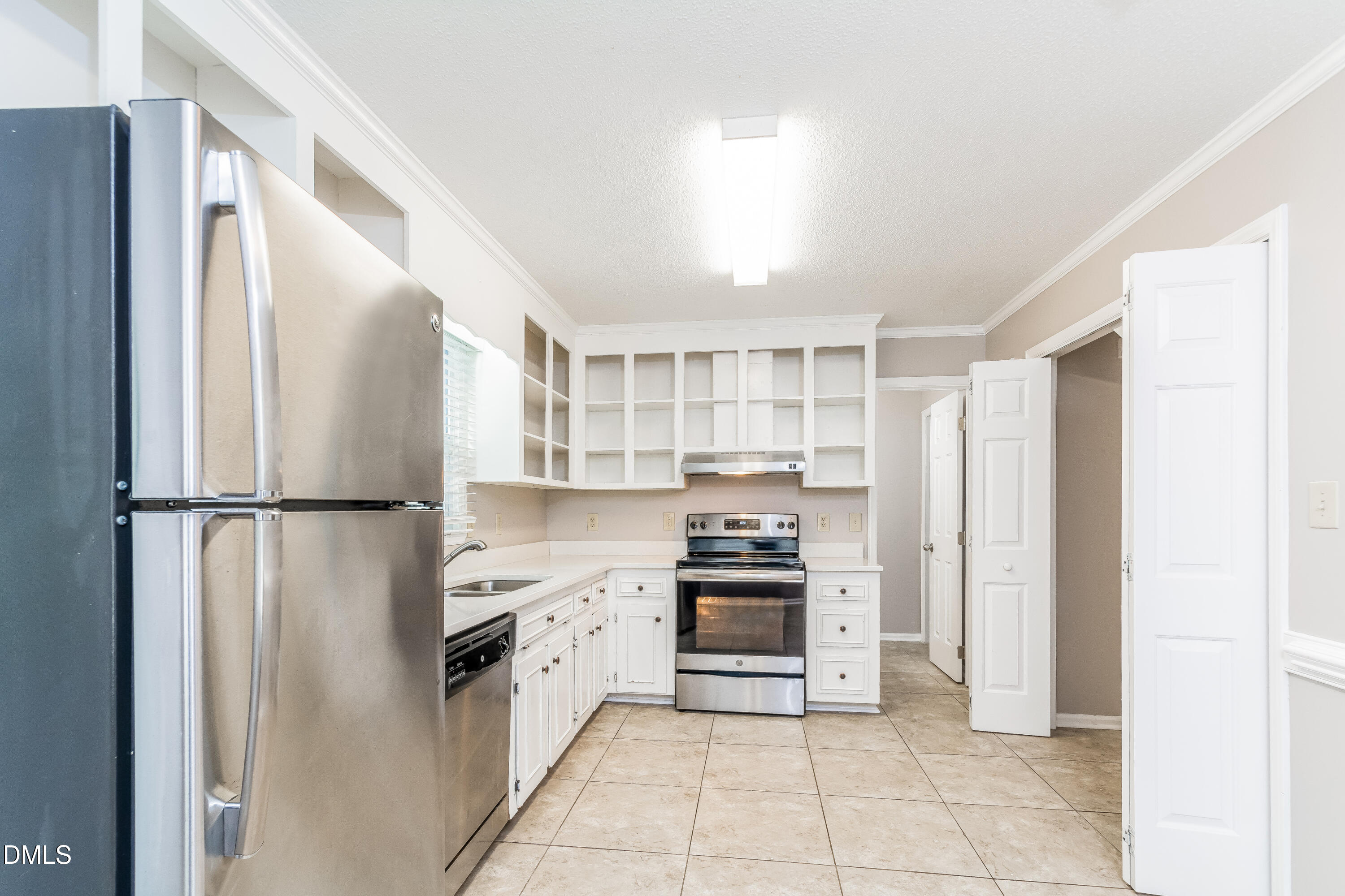 405 Hunters Ridge Drive Fuquay-Varina, NC 27526 - Photo 4 of 17 a kitchen with stainless steel appliances a refrigerator sink and cabinets