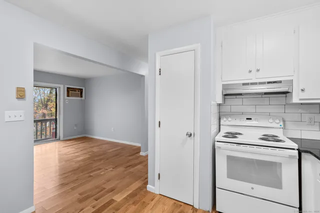 a kitchen with a stove cabinets and wooden floor