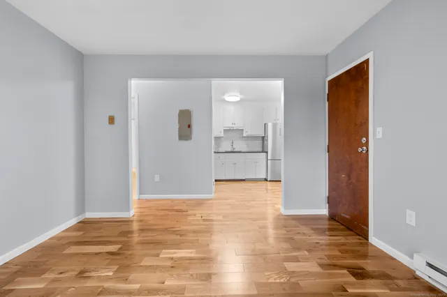a view of empty room with wooden floor