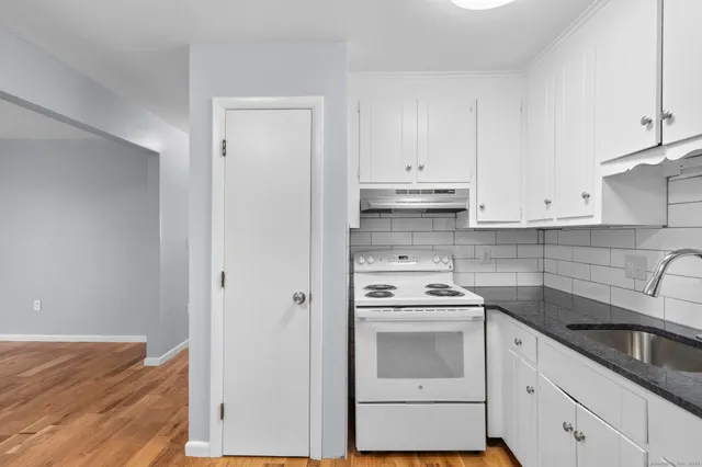 a kitchen with cabinets appliances and a wooden floor