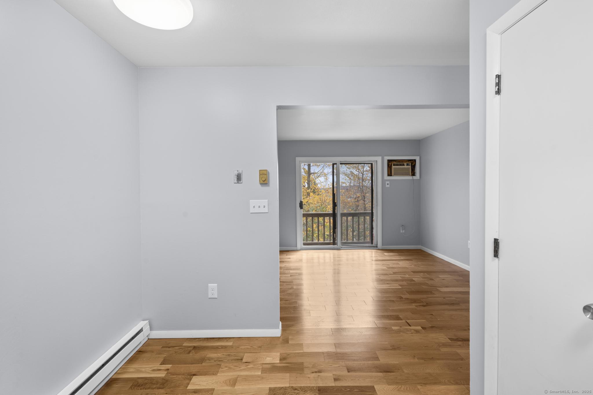 23 Shirley Street, Unit 3 Waterbury, CT 06708 - Photo 6 of 35 a view of an empty room with wooden floor and a window