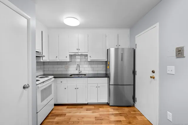 a kitchen with stainless steel appliances granite countertop a refrigerator and a stove top oven