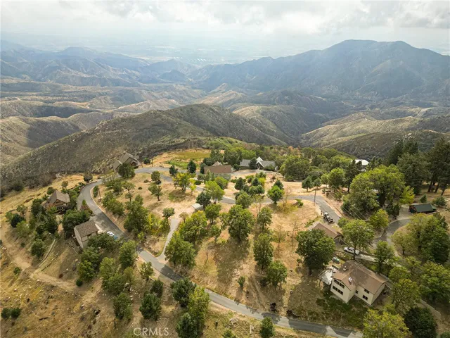 a view of swimming pool with lawn chairs and plants