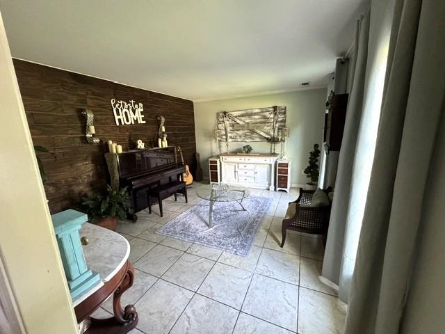 1897 Corbin Road Germantown, TN 38139 - Photo 3 of 22 Spacious interior featuring a prominent wood plank accent wall, light-toned tile flooring, and neutral wall paint