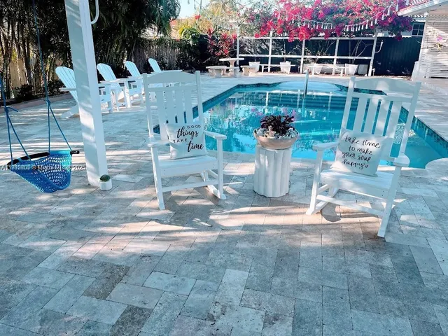a view of a patio with table and chairs potted plants