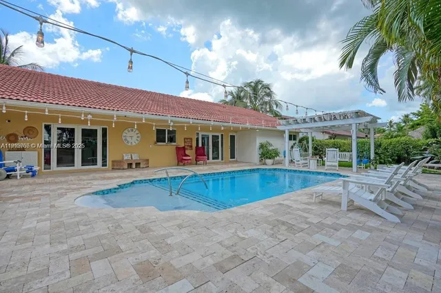 a view of a house with swimming pool and sitting area