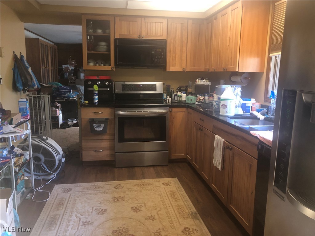3555 Good Road Seville, OH 44273 - Photo 2 of 17 Kitchen with appliances with stainless steel finishes, dark wood finished floors, glass insert cabinets, and dark stone countertops