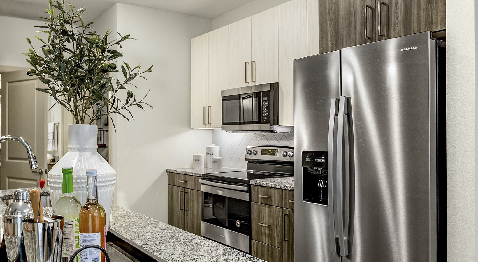7100 Uvalde Road, Unit 10106 Houston, TX 77049 - Photo 14 of 28 a kitchen with stainless steel appliances a refrigerator a stove and a sink