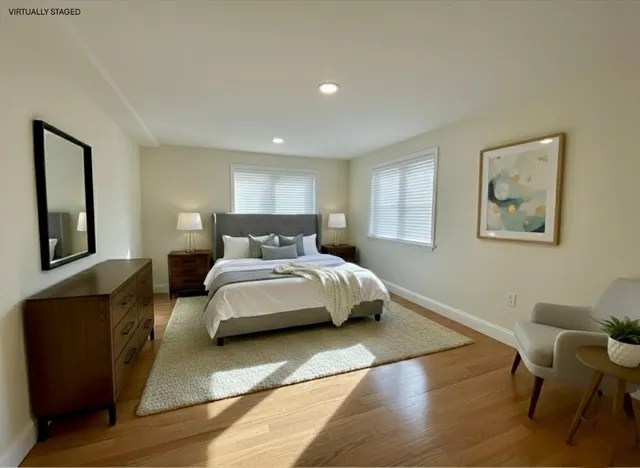 a bedroom with a bed a chair and painting on the wall