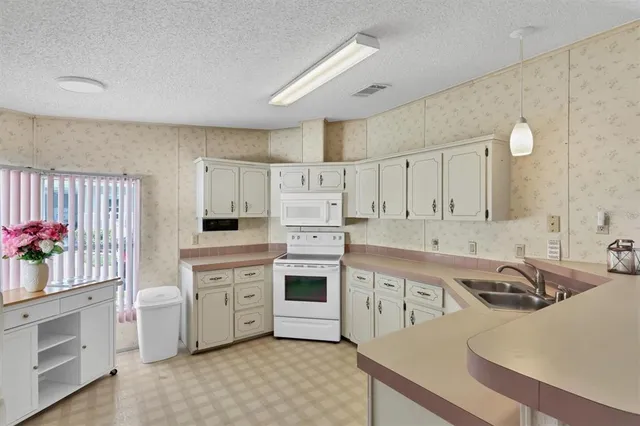 a kitchen with white cabinets appliances and sink