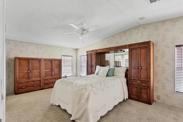 a bedroom with a large bed and a ceiling fan