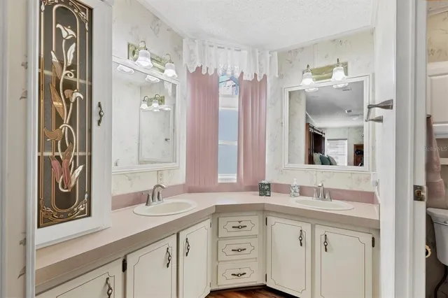 a bathroom with a granite countertop sink toilet a large mirror a vanity and shower