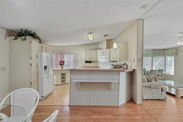 a kitchen that has a lot of white cabinets and stainless steel appliances