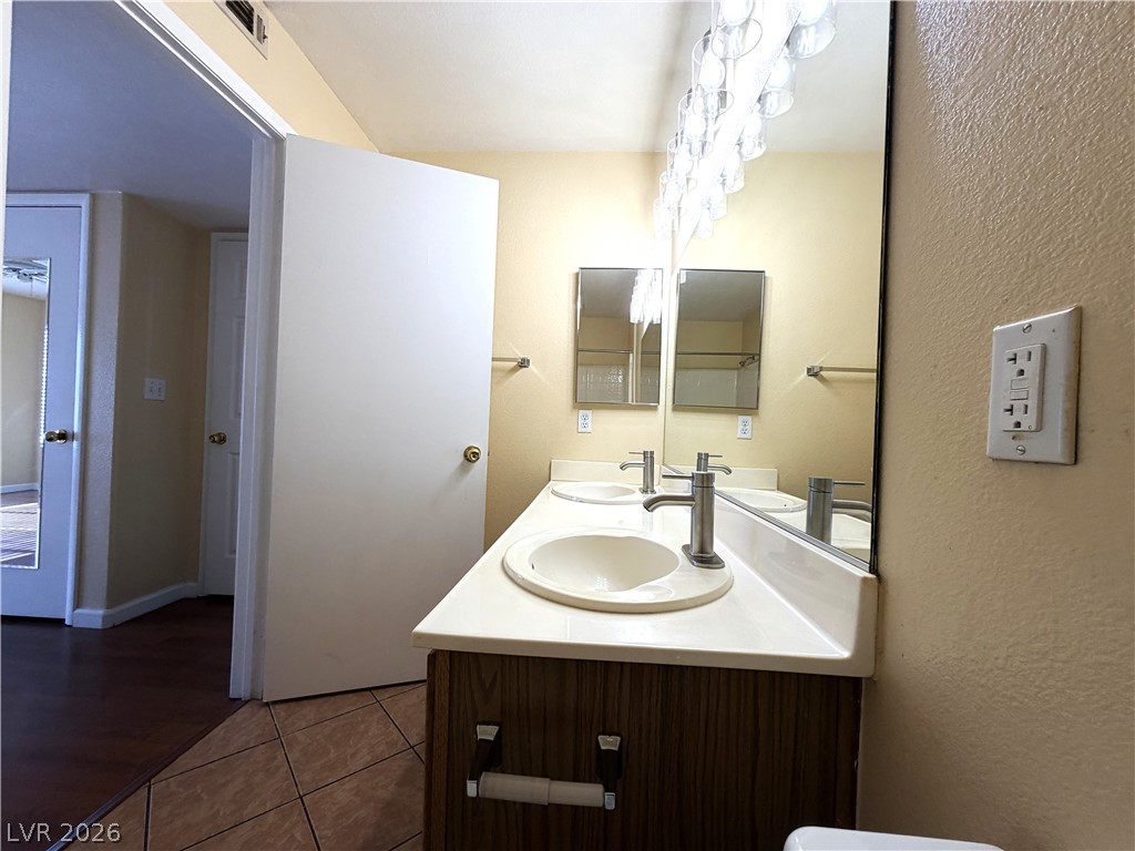 4955 South Lindell Road, Unit 203 Las Vegas, NV 89118 - Photo 21 of 31 Double vanity and a grand mirror elevate this functional bathroom space.