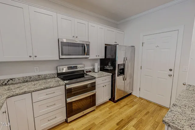 a kitchen with granite countertop a sink stove and refrigerator
