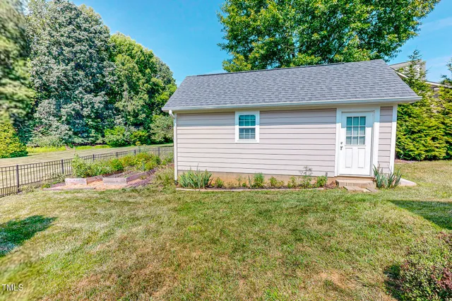 a view of a hallway with wooden floor and a bathroom