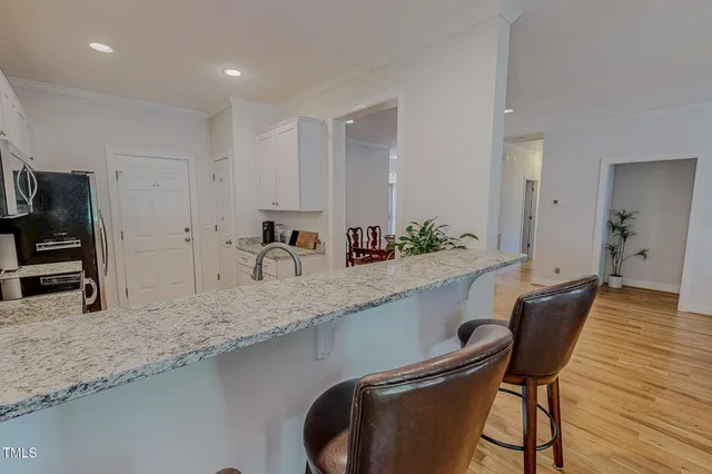 a kitchen with granite countertop sink table and chairs