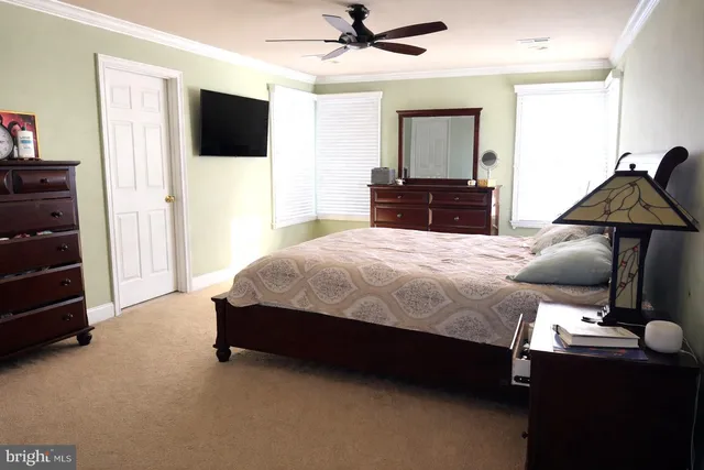a bedroom with a bed and a flat tv screen on dresser