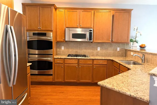 a kitchen with stainless steel appliances granite countertop a refrigerator stove and sink