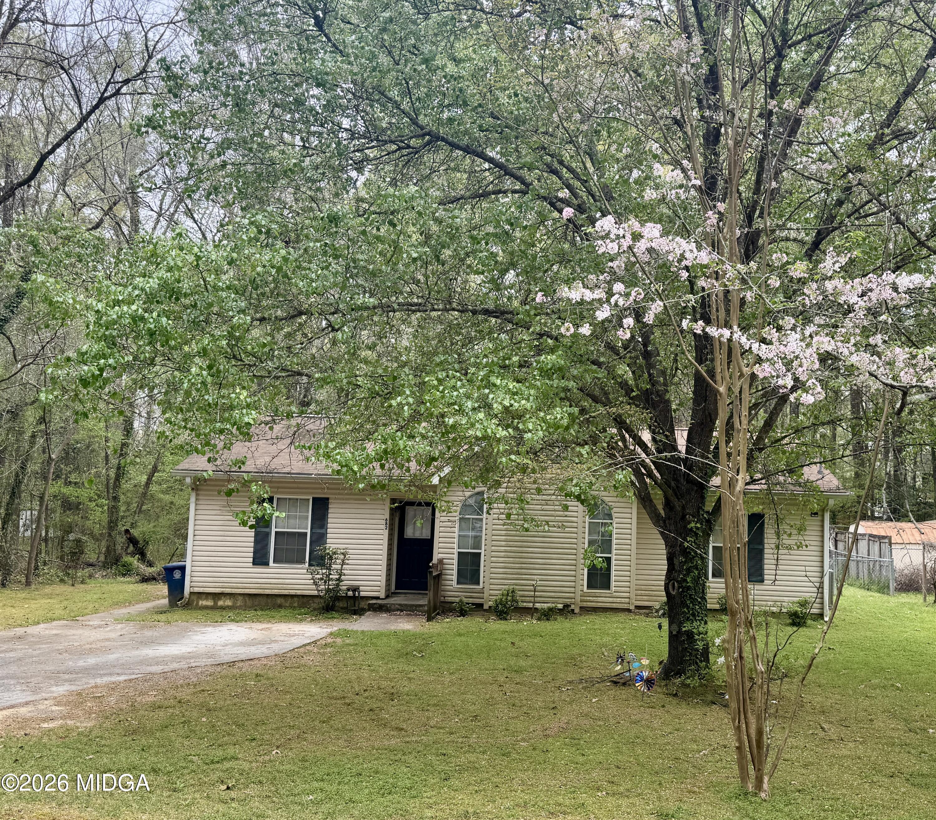 682 Wilderness Drive Macon, GA 31220 - Photo 16 of 25 a front view of a house with a garden and trees